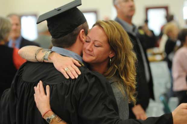 Inmate Steven Clark gets a hug from his girl friend Tomi Doyle after Clark received his associate degree from the University of Maine in Augusta on Monday at the Maine State Prison.